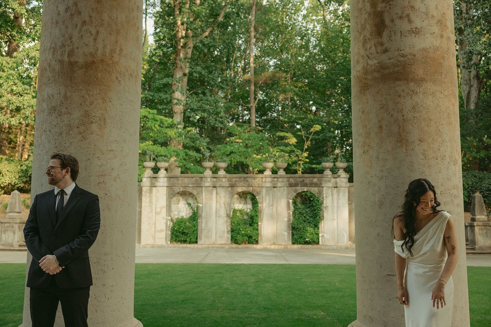Rachel and Jack each beside a stone column, smiling